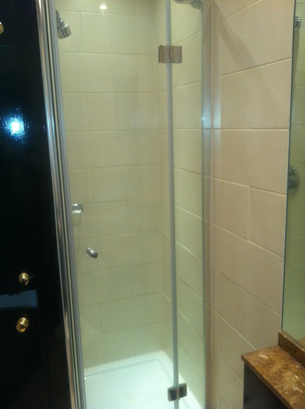 Frameless glass shower enclosure with chrome fittings in Brixton