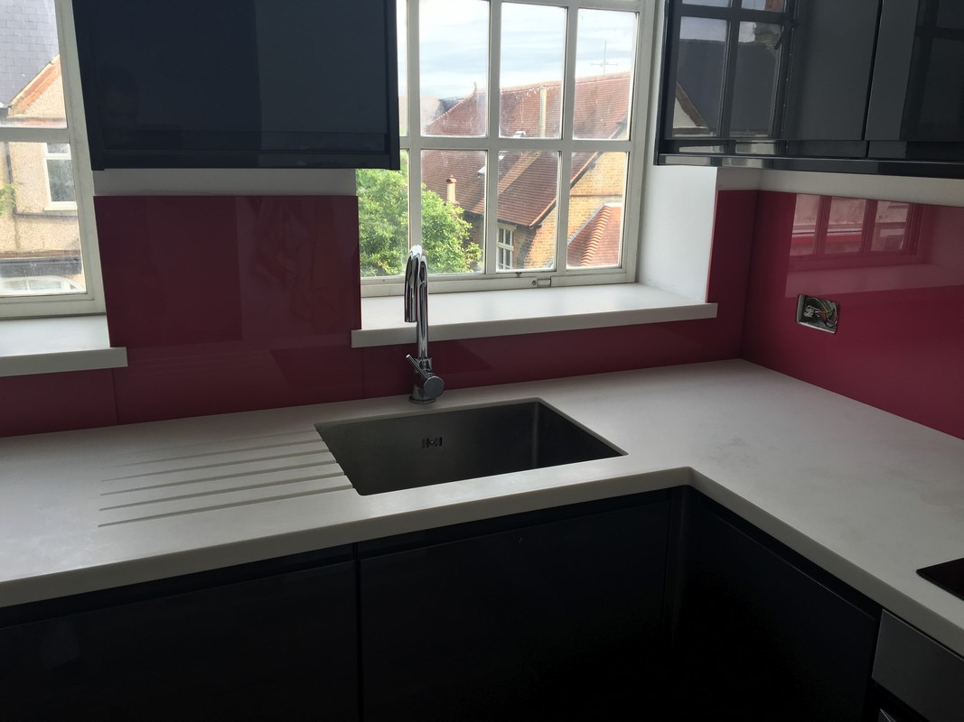 Deep plum coloured glass splashback in modern Brixton kitchen