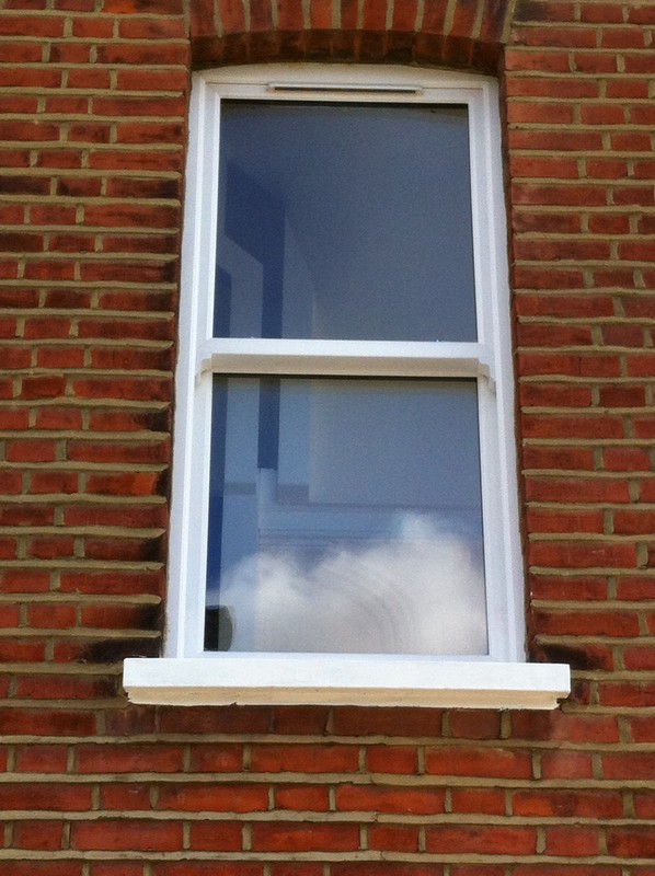 uPVC sash window on Victorian red brick house in Brixton